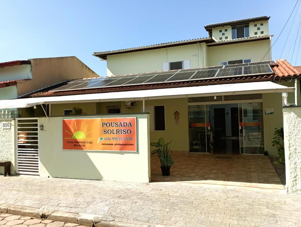 a building with a sign in front of it at Pousada Executiva SolRiso Aeroporto Florianópolis in Florianópolis