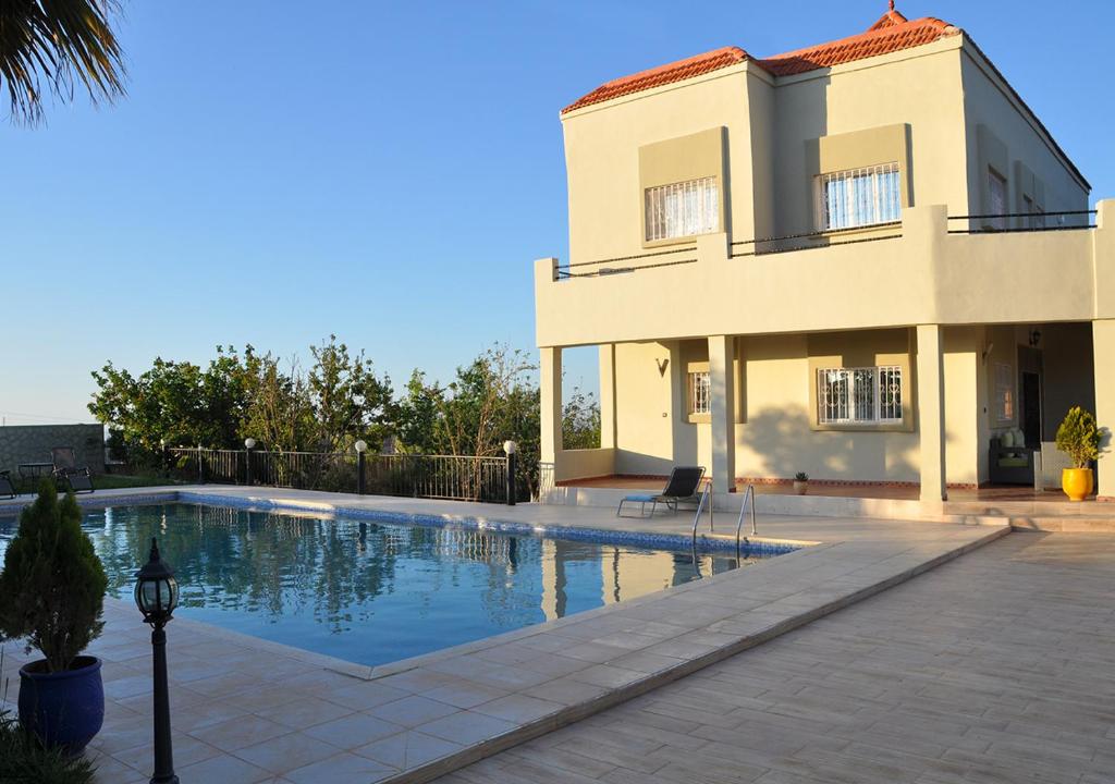 a villa with a swimming pool in front of a building at Vila Haja - Beautiful Farmhouse with a Private Pool! in Imouzzer Kandar