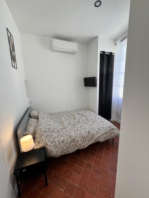 une chambre avec un lit dans une petite pièce dans l'établissement Studio Proche Toutes Commodités, à Perpignan