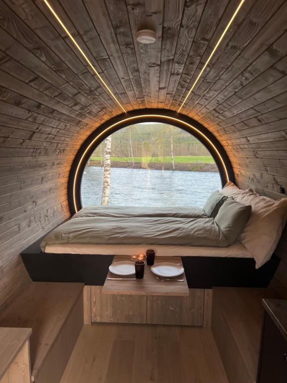Bett in einem kleinen Zimmer mit Fenster in der Unterkunft Dreamy Barrel in Ljotegard