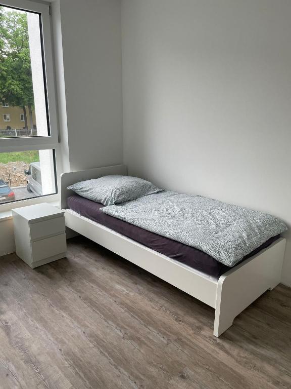a bed in a white room with a window at boll appartments GmbH Taucha in Taucha