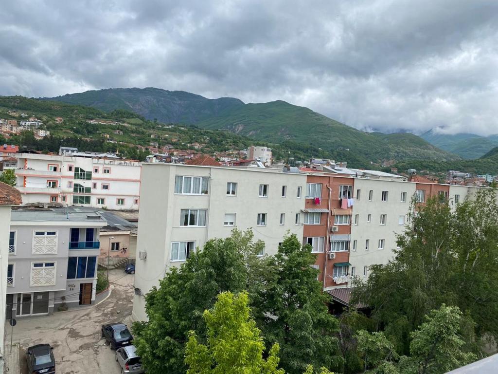 Hotel brazil في Peshkopi: مجموعة مباني فيها جبال في الخلف