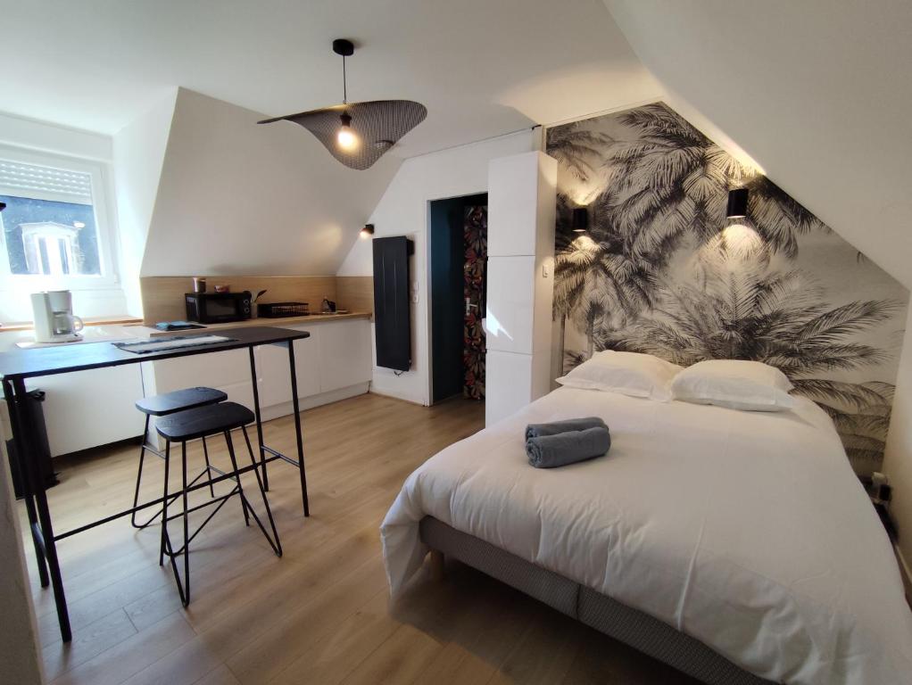 a bedroom with a bed and a desk and a kitchen at LE ARA - Gare - centre ville - By Nid'Ouest in Quimper