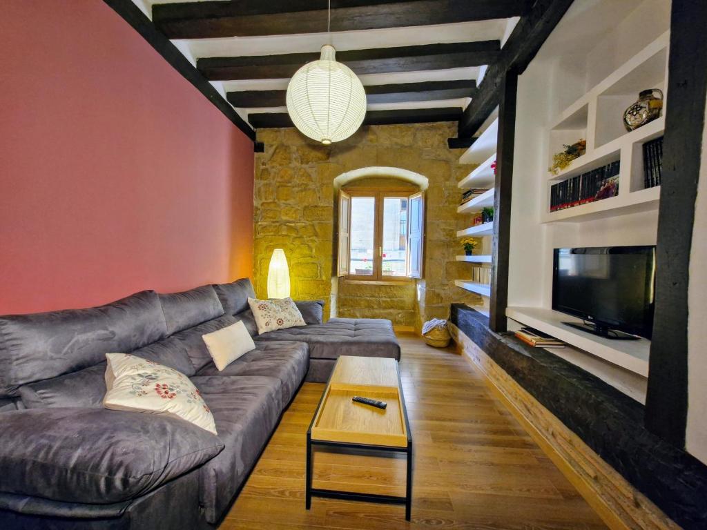 a living room with a couch and a tv at Casa de la tía Irene in Briñas