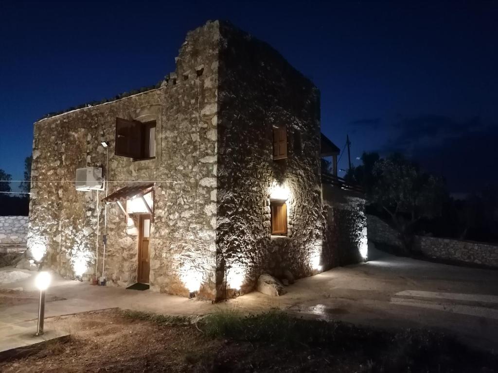 un edificio de piedra con luces encendidas por la noche en Xemoni House, en Koíta