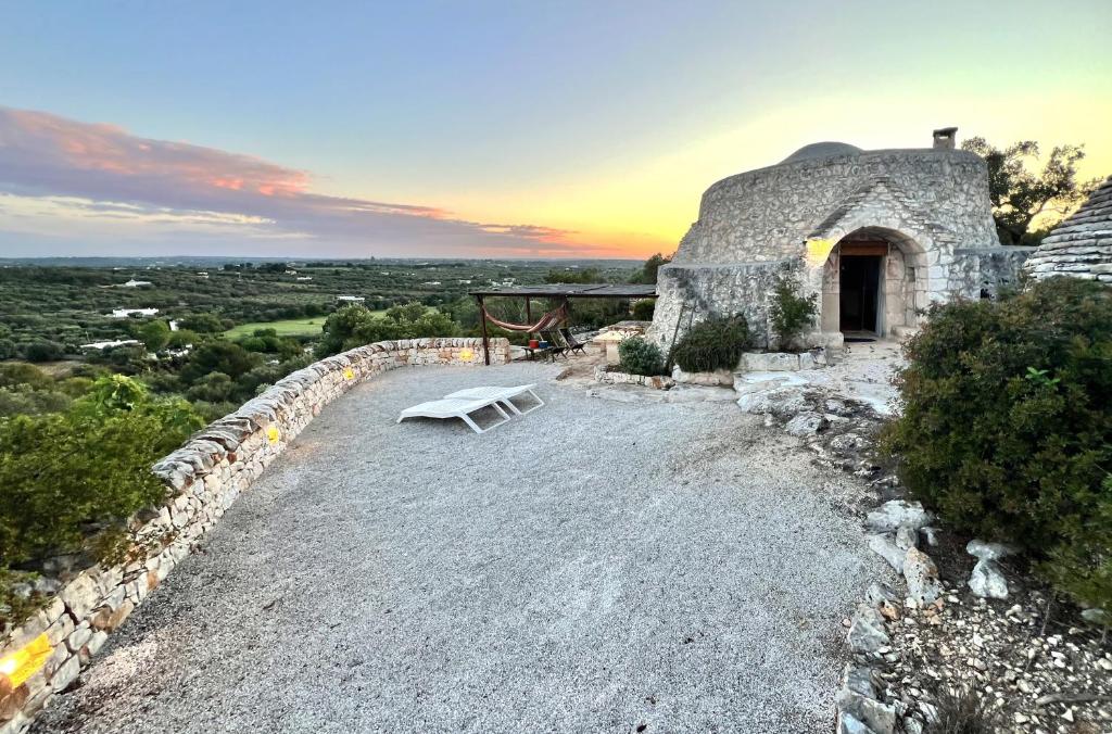 a bench sitting on the side of a stone house at Trullo fiore in Ostuni