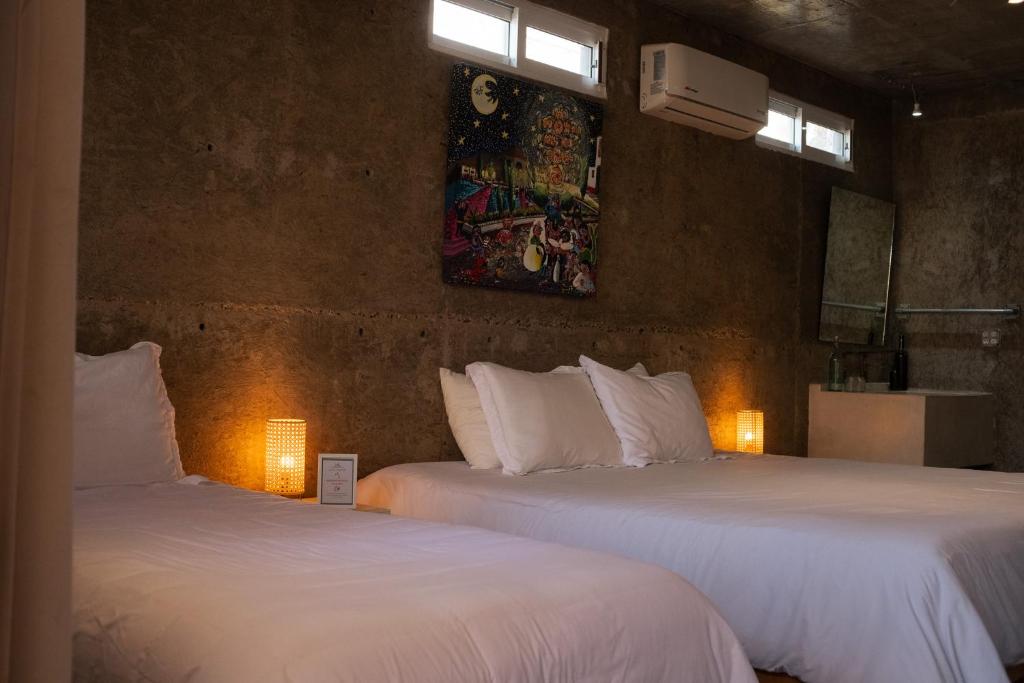dwa łóżka w pokoju z dwoma światłami w obiekcie Hotel Perro Surfero Todos Santos w mieście Todos Santos
