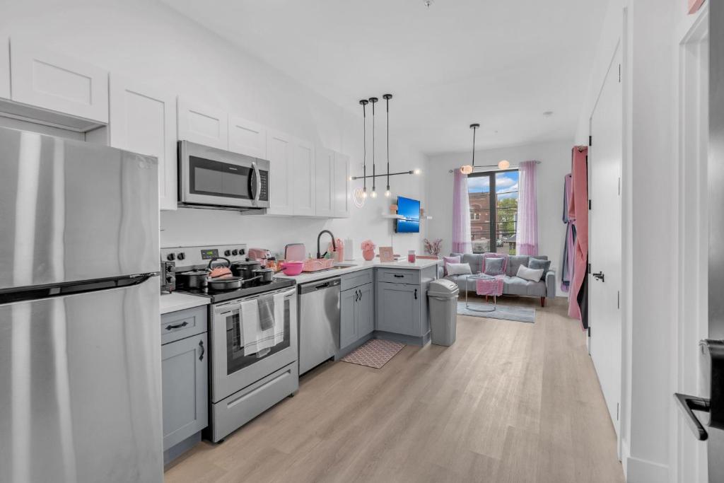a kitchen with stainless steel appliances and a living room at Pink Heaven in Elizabeth