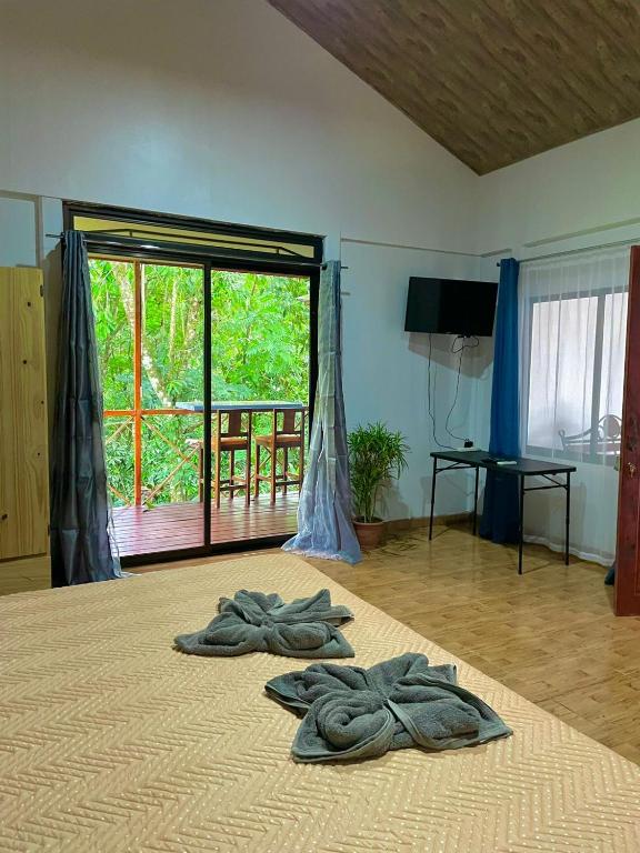 a room with two towels on a bed with a window at Cabañas el Bosque del Arenal in Guayabal