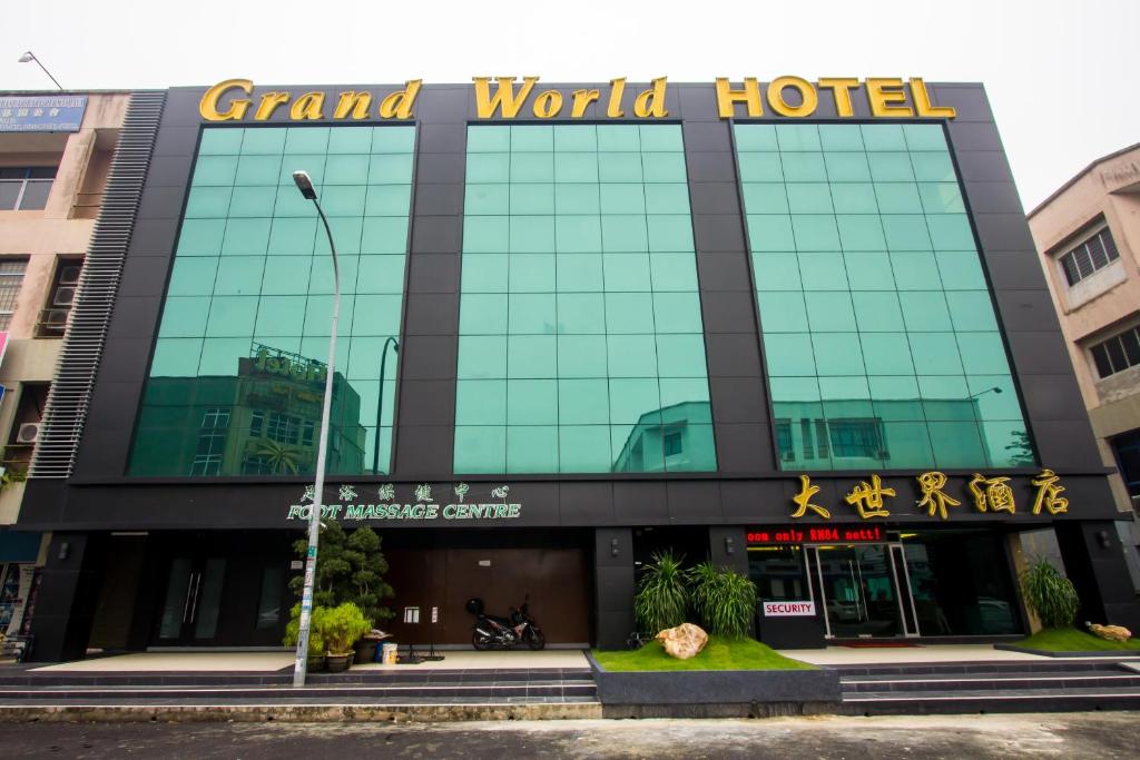 um grande edifício de vidro com uma placa que lê o grande hotel do mundo em Grand World Hotel em Johor Bahru