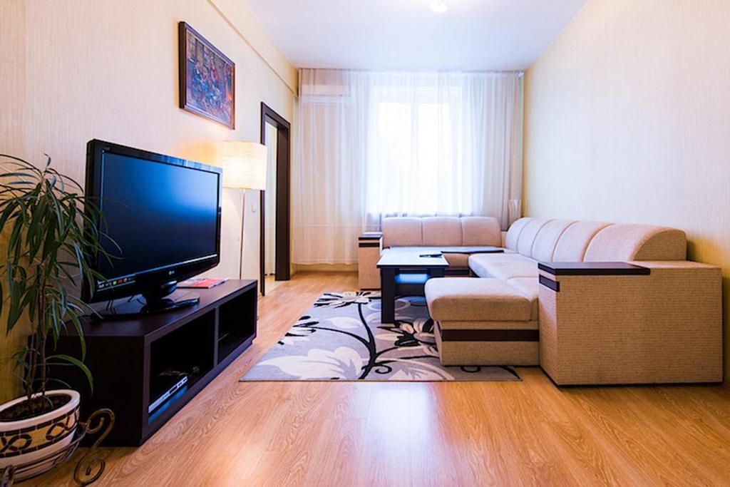 a living room with a couch and a flat screen tv at Studiominsk Apartments in Minsk