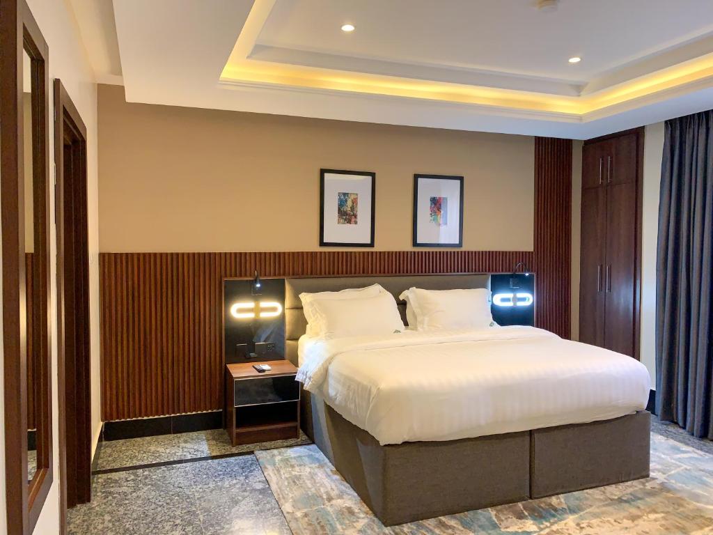 a bedroom with a large bed in a room at Five Homes Hotel and Apartments in Abuja