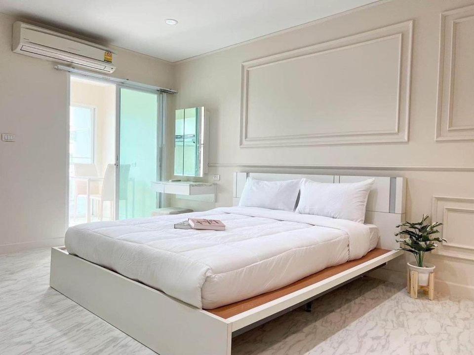 duże białe łóżko w pokoju z oknem w obiekcie Vacation pool condo w mieście Ban Rangeng