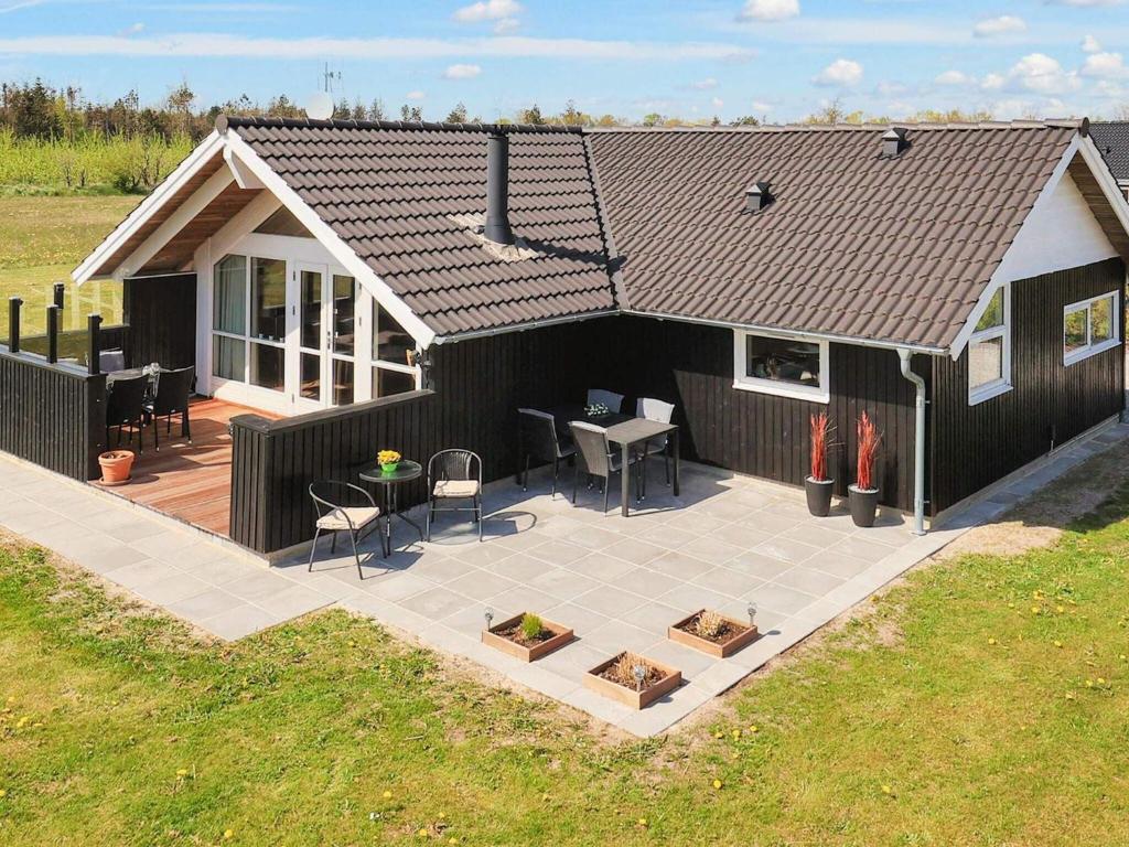 a house with a patio with a table and chairs at 6 person holiday home in Hadsund in Øster Hurup