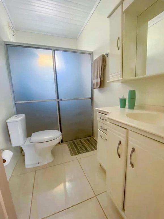 a white bathroom with a toilet and a sink at Recanto santa esmeralda in Sorocaba