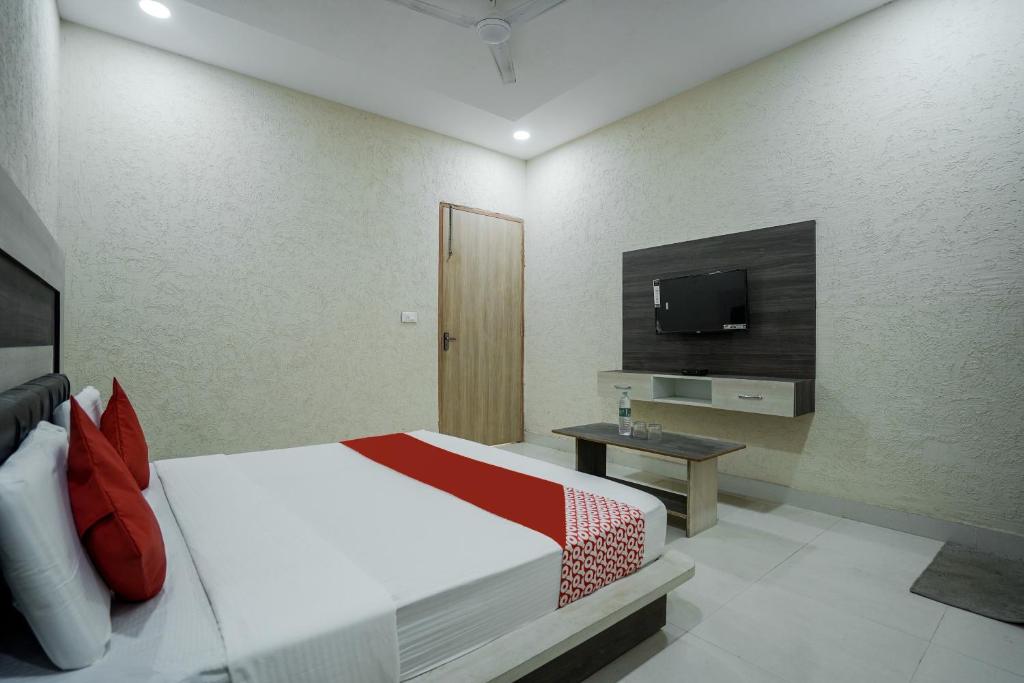 a bedroom with a bed and a tv on a wall at Hotel Prime Rose in Kurukshetra