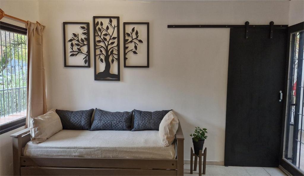 a living room with a couch and pictures on the wall at Magnifico Departamento En La Ciudad De Mendoza in Barraquero
