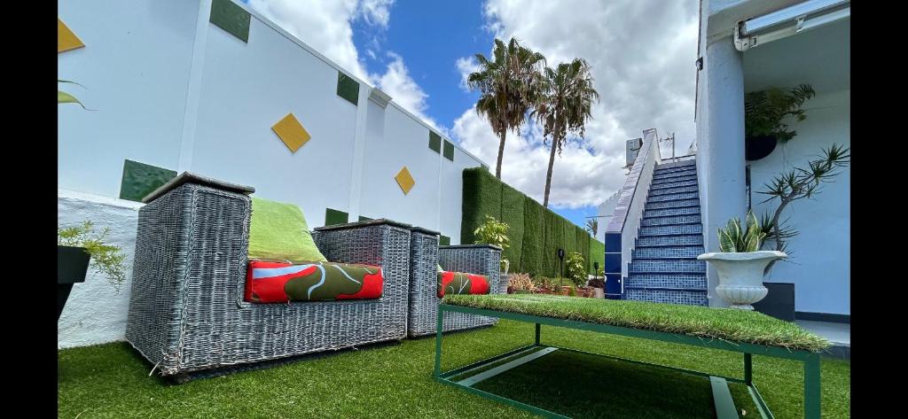 ein Zimmer mit einer Bank und einigen Pflanzen und einem Gebäude in der Unterkunft VISION RELAX HOME in Playa del Ingles
