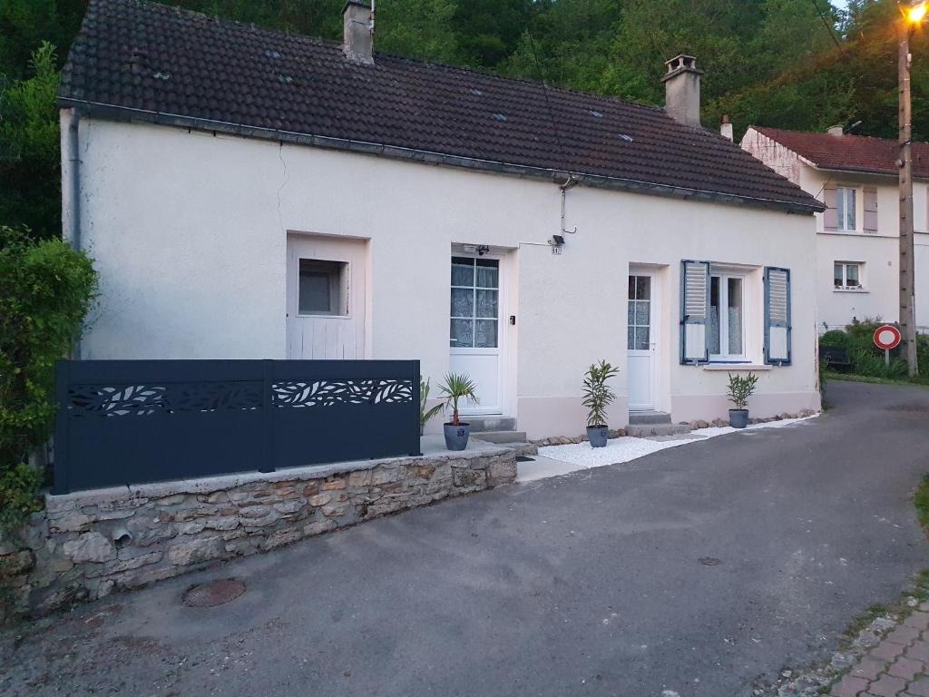 a white house with a sign in front of it at La Maison du Druide in Bonneuil-en-Valois