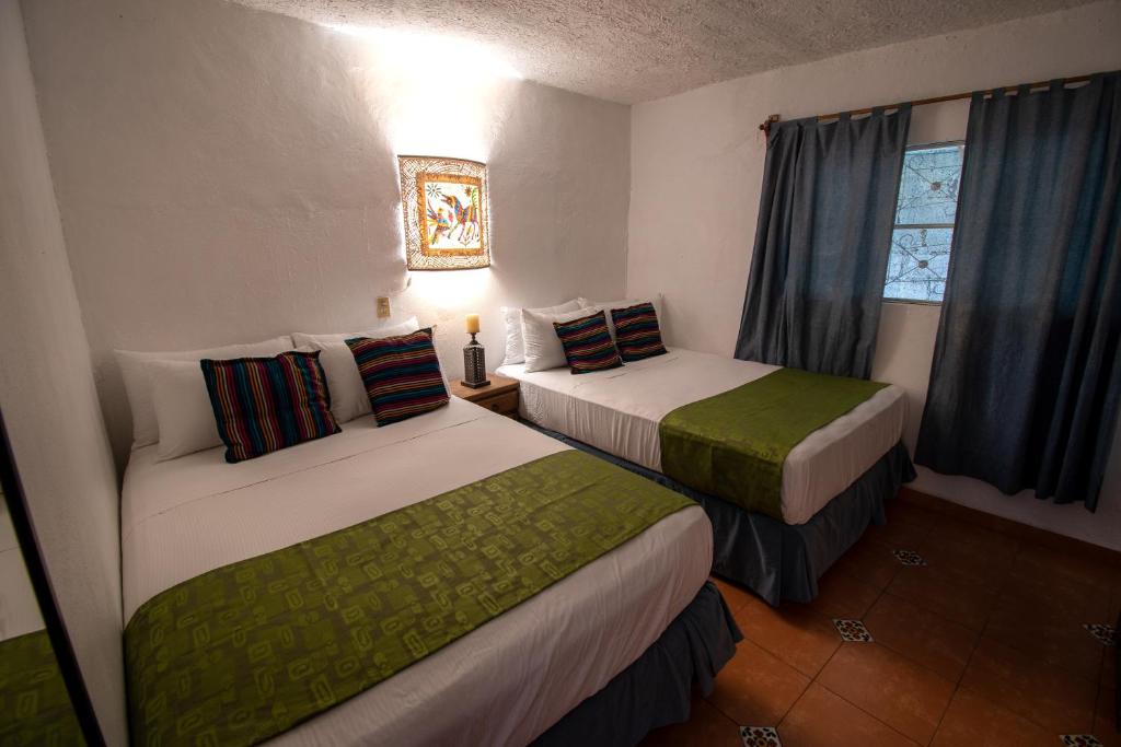 ein Hotelzimmer mit 2 Betten und einem Fenster in der Unterkunft Hostal Doña Emma in Pahuatlán del Valle