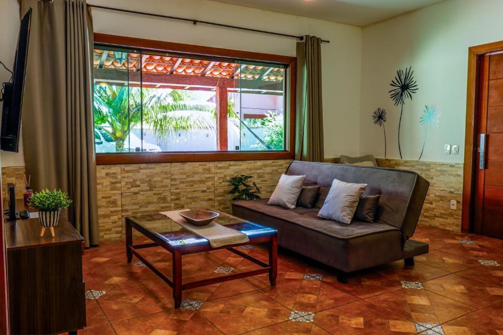 a living room with a couch and a table at Bella casa da paz in Búzios