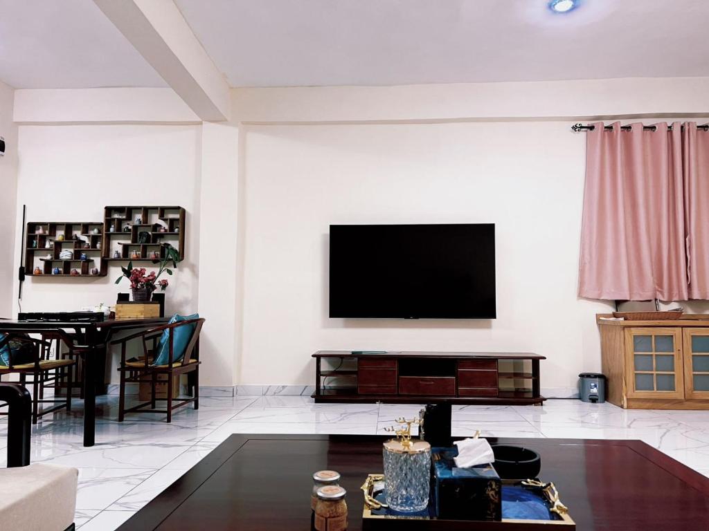 sala de estar con TV de pantalla plana en la pared en Grand Leone Hotel en Freetown