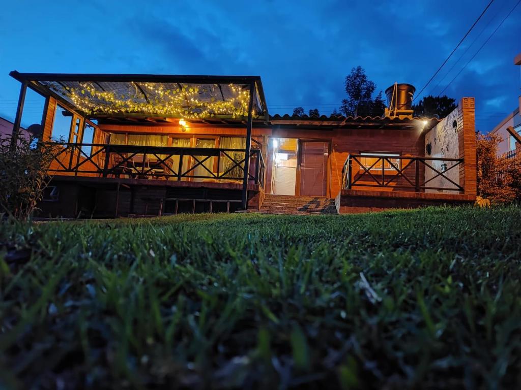 una casa con una terraza grande por la noche en Villa Bremen, Hospedaje Rural con vista al Lago, en Paipa