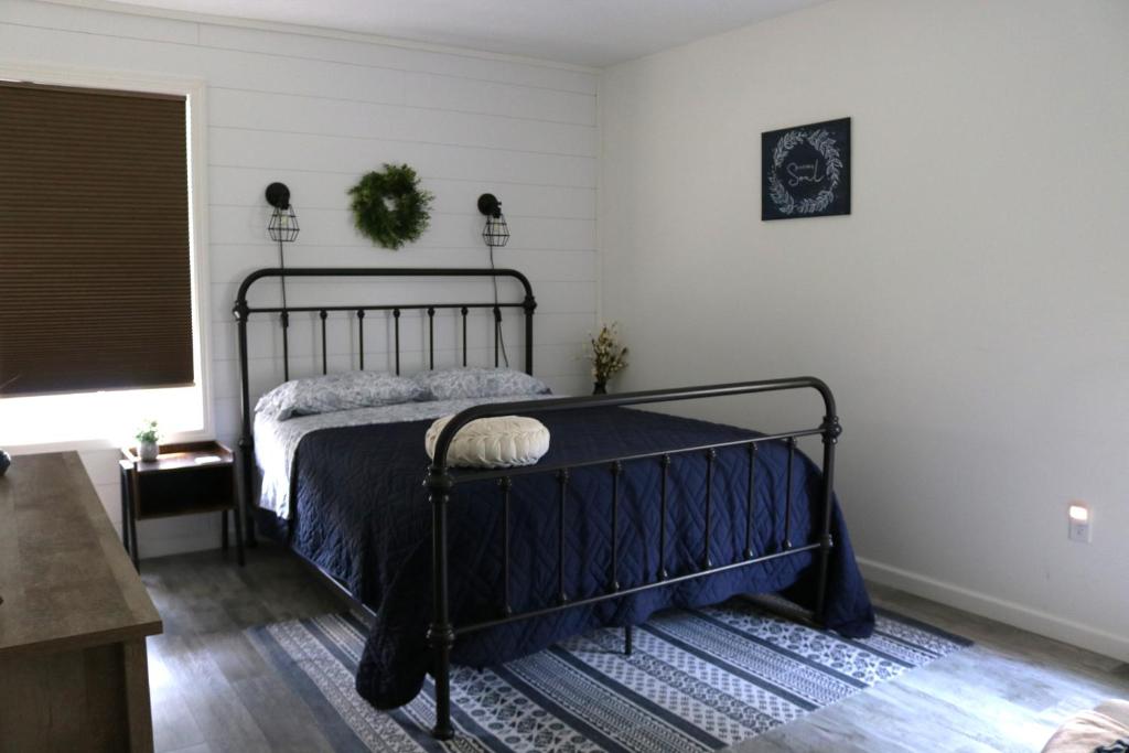 ein Schlafzimmer mit einem schwarzen Bett in einem Zimmer in der Unterkunft Country Hills Hideaway in Millersburg