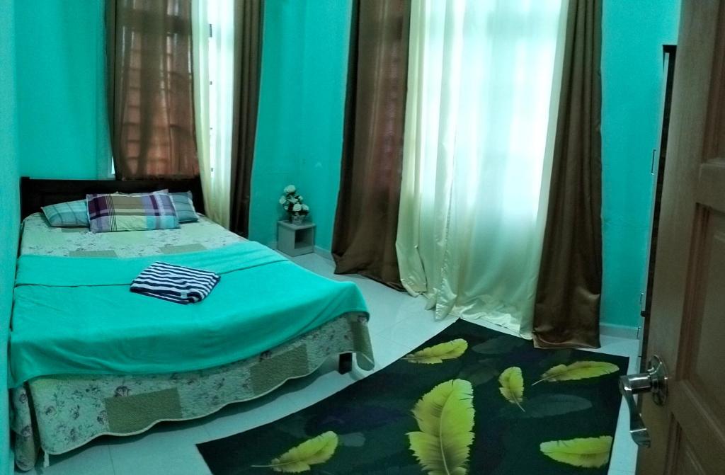 Łóżko lub łóżka w pokoju w obiekcie Homestay & Roomstay Airport Kelantan