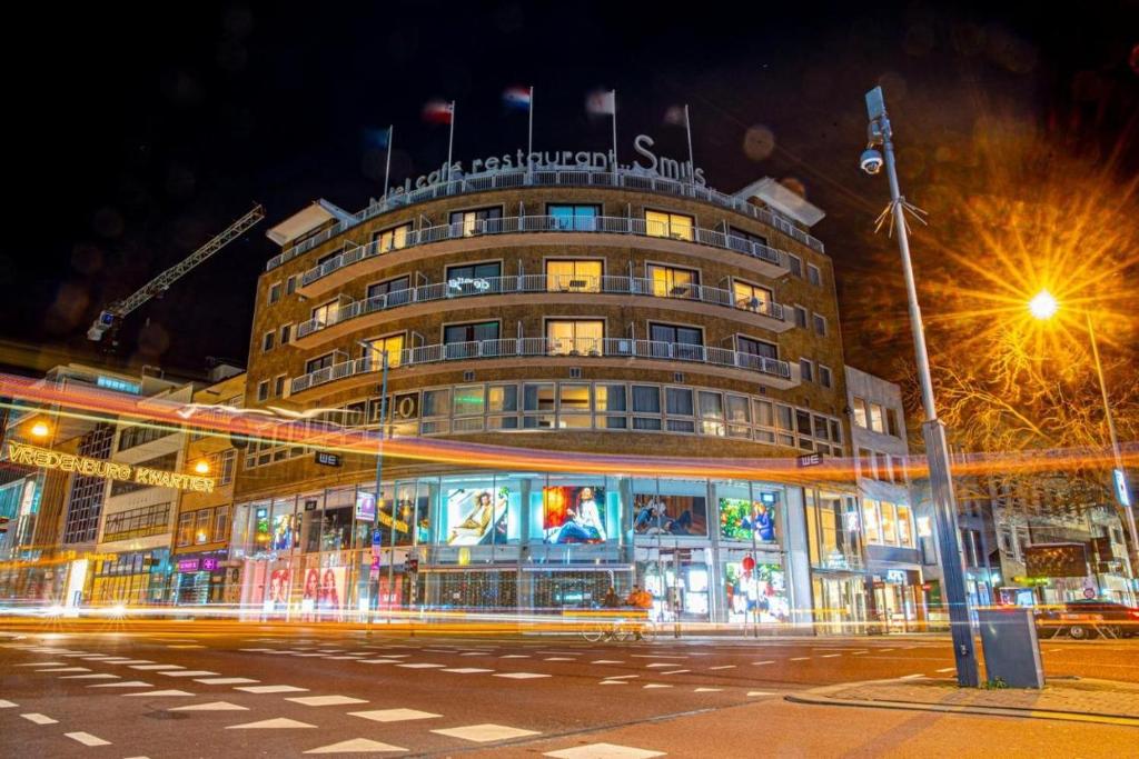 Un palazzo alto con un cartello sopra. di Leonardo Hotel Utrecht City Center a Utrecht