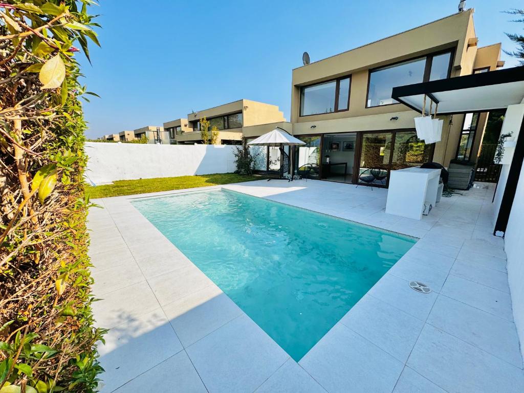 a swimming pool in front of a house at Casa amoblada Chicureo Santiago in Colina