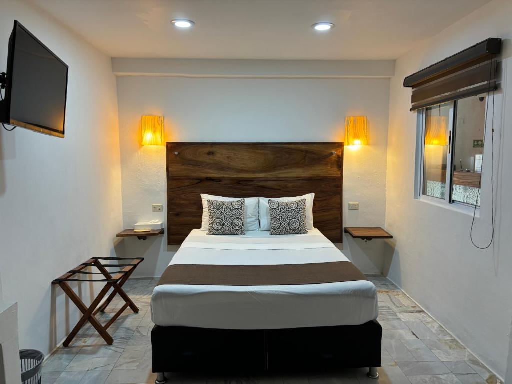 um quarto com uma cama grande e uma televisão de ecrã plano em Ixaya em Puerto Vallarta