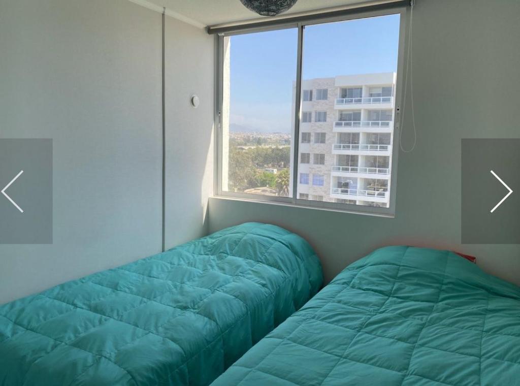 Habitación con 2 camas frente a una ventana en Departamento Amoblado en La Serena, en La Serena