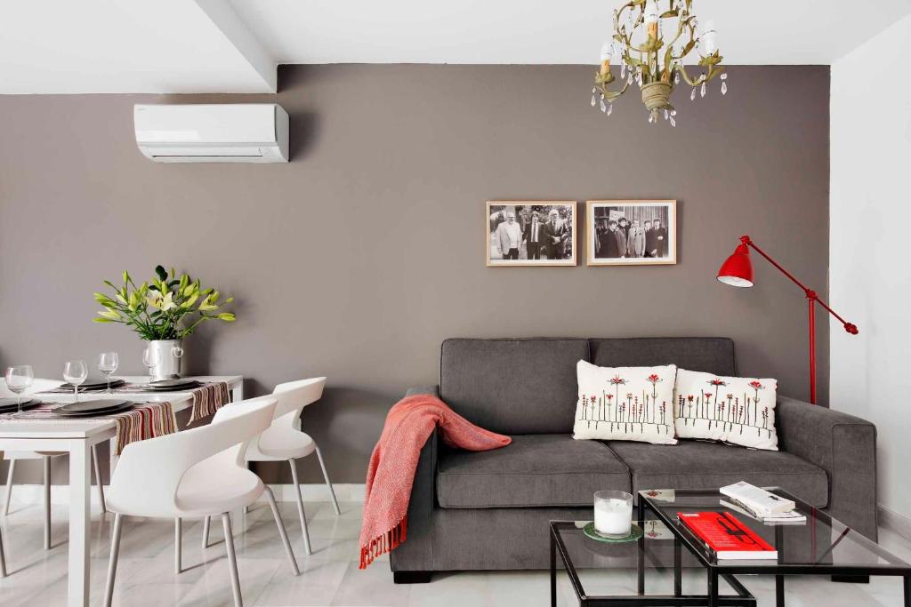 un soggiorno con divano e tavolo di Apartamentos Mariscal a Siviglia
