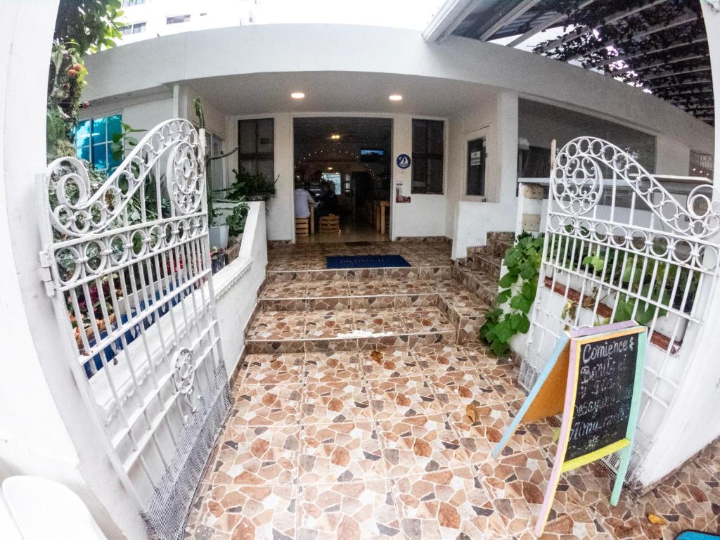 un corridoio con cancelli bianchi e pavimento piastrellato di Nahimara Champeta Hostel a Cartagena de Indias
