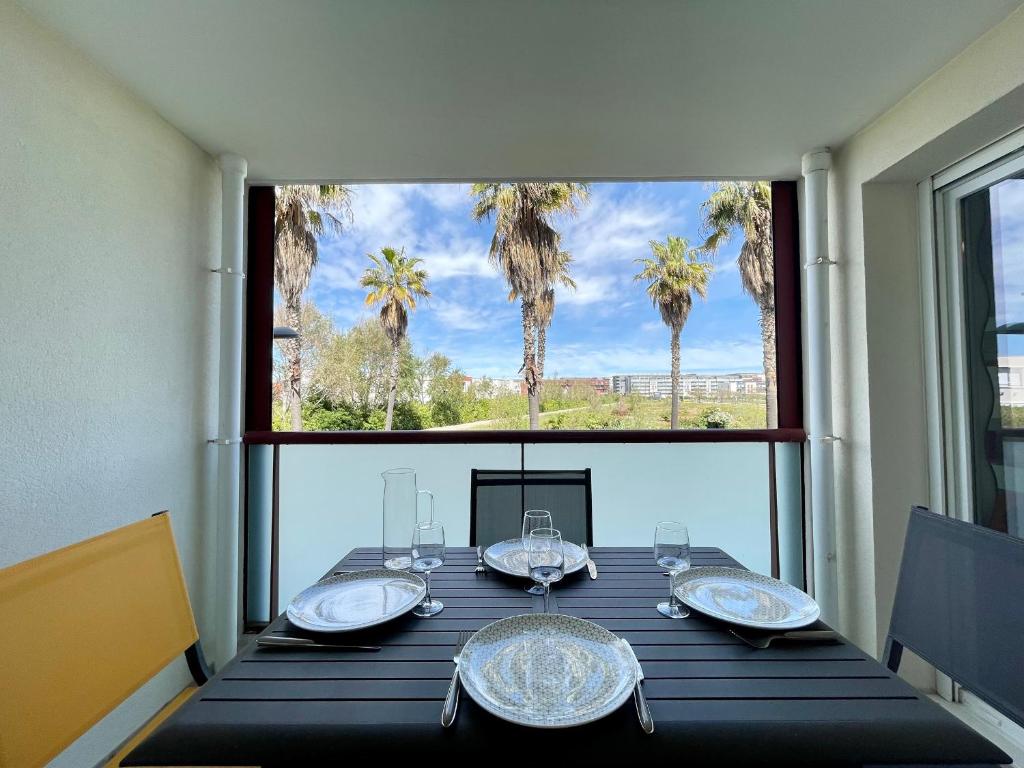 une salle à manger avec une table et une grande fenêtre dans l'établissement Appartement climatisé 3 pièces avec garage à 300m de la plage et des commerces à Sète - FR-1-338-576, à Sète