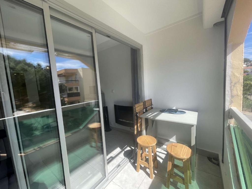 un balcon avec un bureau et deux chaises et une table dans l'établissement Studio cosy avec loggia, proche plage - LA FAVIERE, Bormes - FR-1-308-196, à Bormes-les-Mimosas
