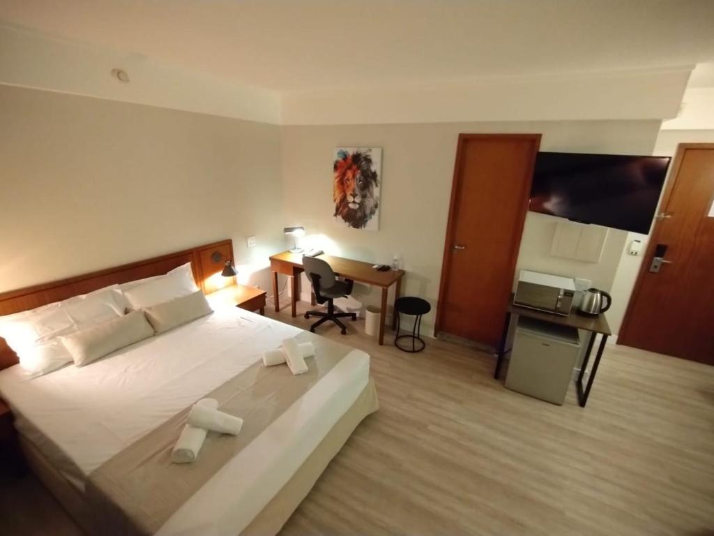 ein Hotelzimmer mit einem großen Bett und einem Schreibtisch in der Unterkunft UH 905 Flat Live Logde Vila Mariana Pq Ibirapuera in São Paulo