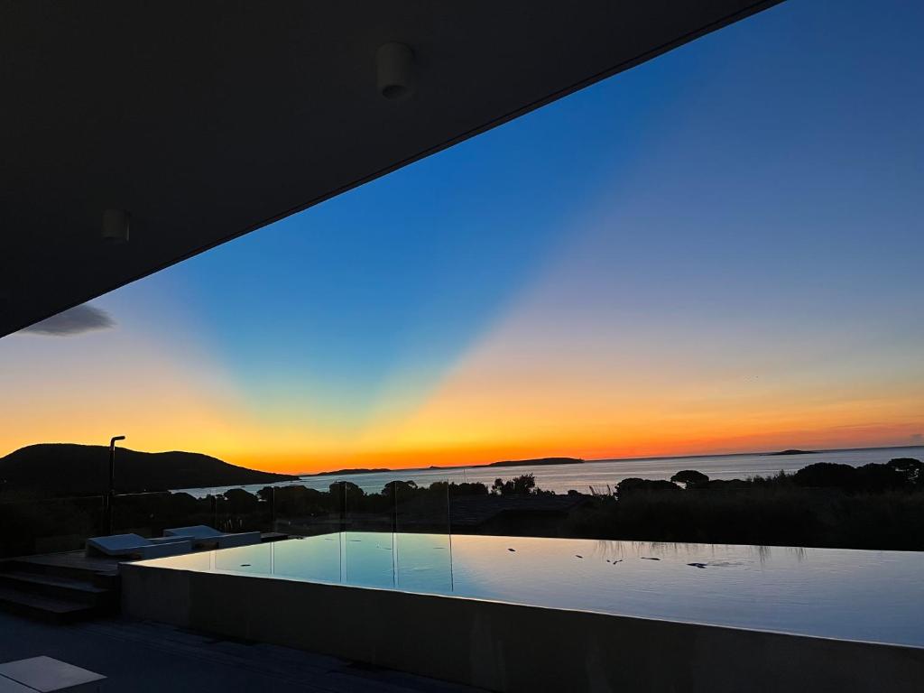 Cette maison avec piscine offre une vue sur le coucher du soleil. dans l'établissement Porto-Vecchio Palombaggia Villa Azaïtù, à Porto-Vecchio