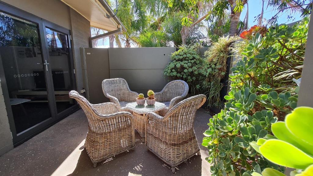 four wicker chairs and a table on a patio at The Good Life in Port Pirie