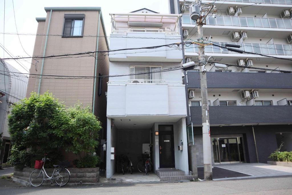 um edifício com uma bicicleta estacionada em frente em Happy Osaka House em Osaka