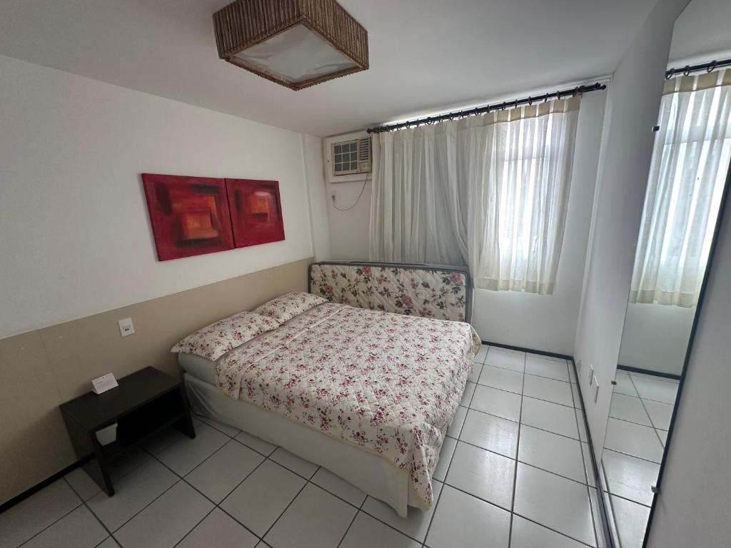 Un dormitorio pequeño con una cama y una ventana. en Gran Lençóis Flat Residence, en Barreirinhas
