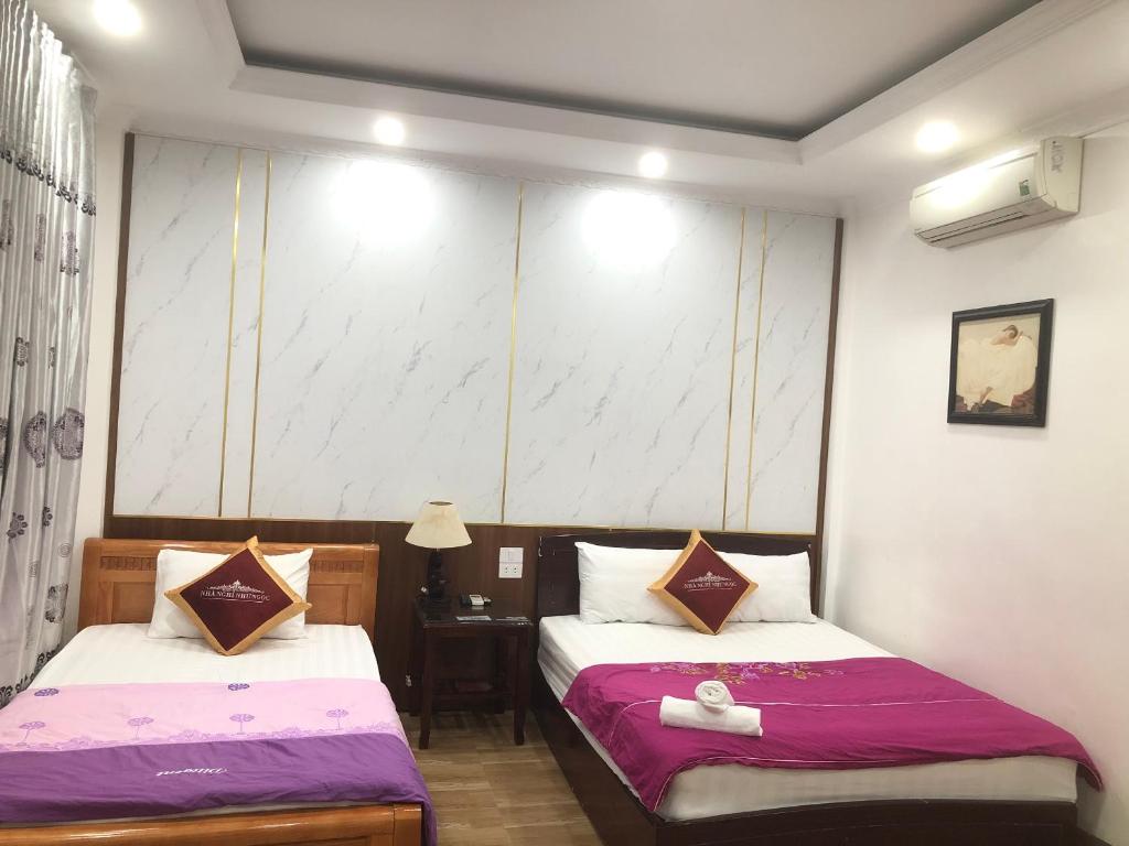 Habitación de hotel con 2 camas y mesa en Nhà nghỉ Như Ngọc, en Diện Biên Phủ