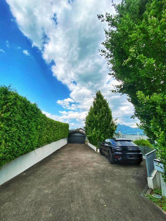 a car parked in a driveway next to a hedge at Luxury loft on top of Villa Wilen with tremendous views by the lake in Sarnen