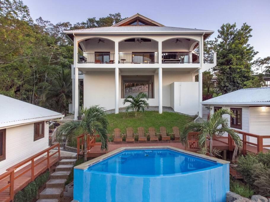 une maison avec une piscine en face de celle-ci dans l'établissement Apricari House Stunning Views 3 BDRM and Pool, à Roatán