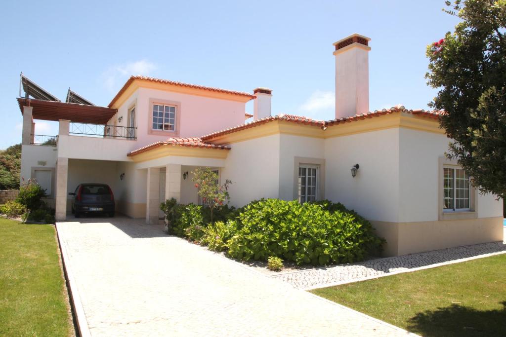 a house with a car parked in the driveway at Villa Casa Dina in Casal da Lagoa Seca