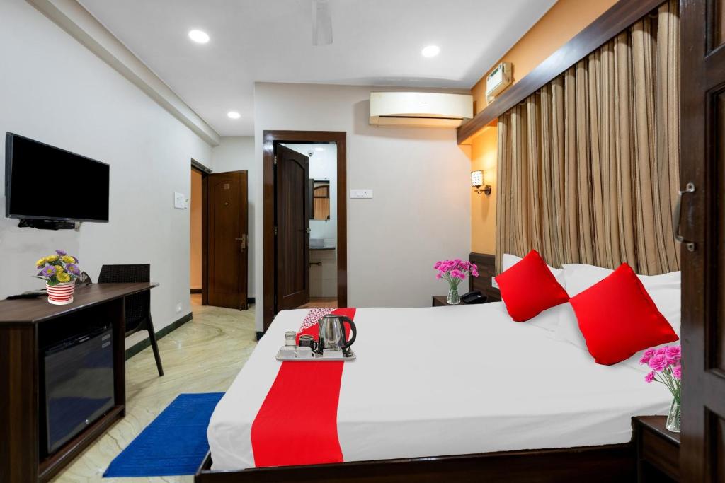 Schlafzimmer mit einem Bett mit roten Kissen und einem Schreibtisch in der Unterkunft Oceana The Holiday Home Near Immaculate Conception Church in Panaji