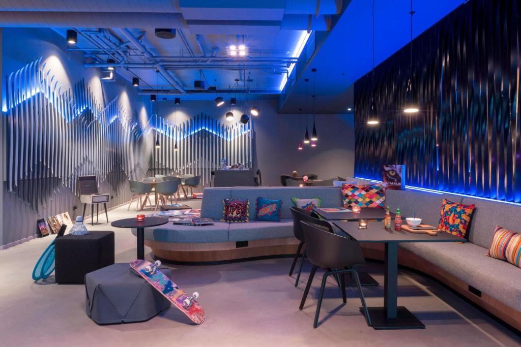 um quarto com um sofá, uma mesa e um skate em X Hotel em Skjetten