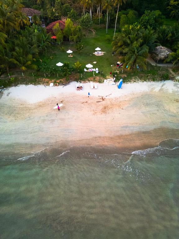 an aerial view of a beach with people on it at Calma - Surf, Yoga & Coffee on a Private Beach in Dickwella