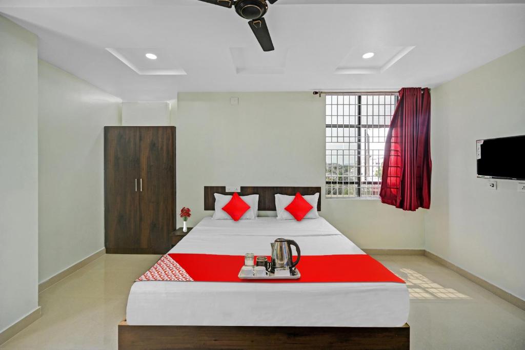 una camera con un letto con una coperta rossa e bianca di OYO VRK Residency a Kurmannapalem
